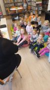 Dzieci siedzą i uważnie słuchają czytanego opowiadania.